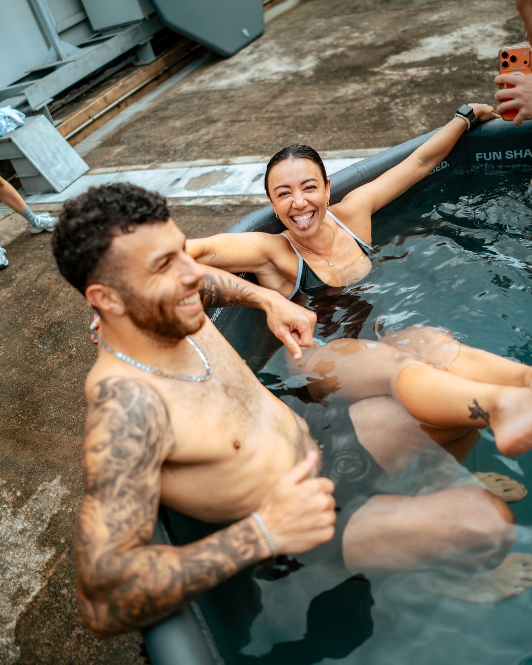 Friends laughing together in a TUNDRA cold plunge at Good Vibes Social, FOC By The Beach Singapore