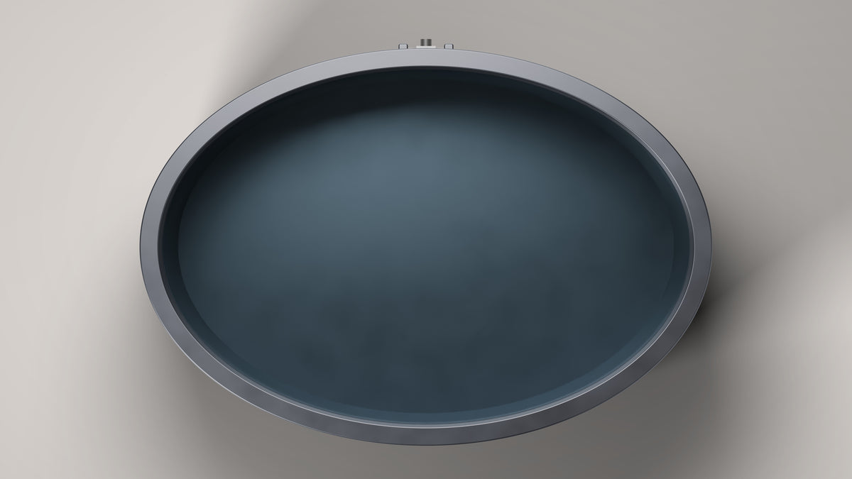 The Inari seen from above: the 1,540 by 1,070 mm oval opening, black stainless steel interior and the connections on the centre of the back
