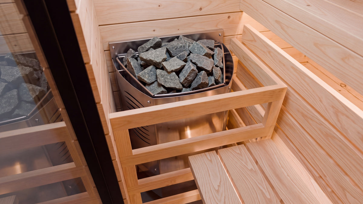 Inside the Ounas: the wall-mounted Harvia stove with its sauna stones and the spruce guard, warm LED light on the benches