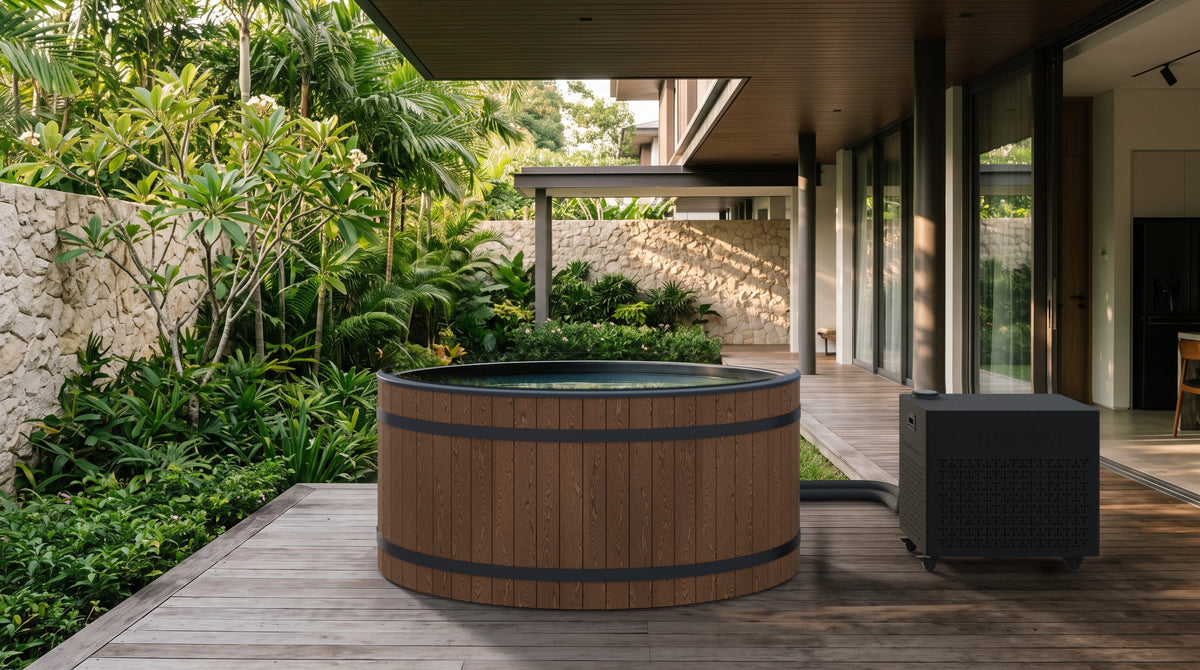 The Inari System on a covered timber deck beside a tropical garden, with the hoses running behind the tub to the Borealis chiller