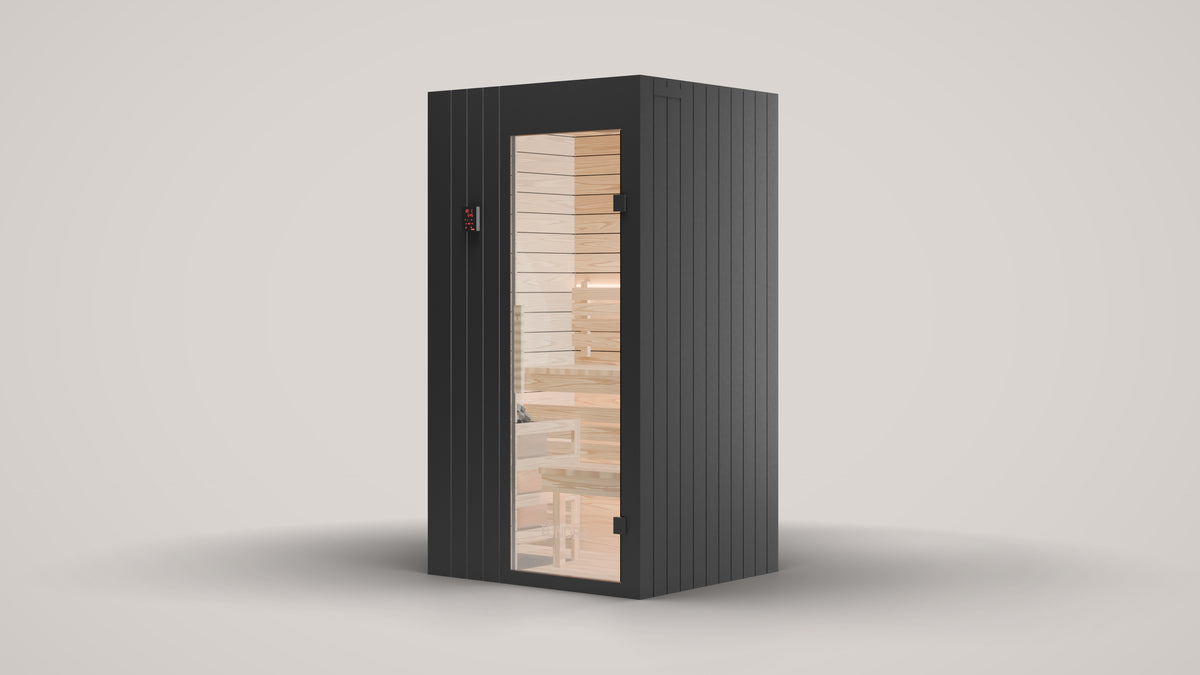 The TUNDRA Ounas indoor Finnish sauna for two, three quarter front right view: black vertical timber boards on the front and sides, glass door on the right, spruce interior